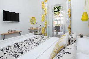 a white bedroom with a bed and a television at Apartments Diana - NEW heated pool in Bol