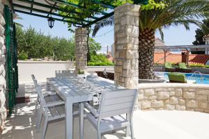 a table and chairs on a patio with a pool at Apartments Diana - NEW heated pool in Bol