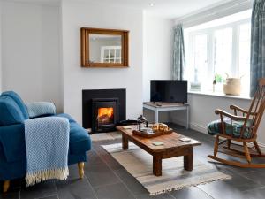 a living room with a blue couch and a fireplace at Morolwg in Borth
