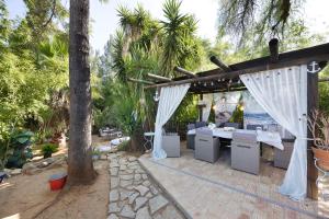 un patio con una mesa y una pérgola en Marine House Spa, en Tavira