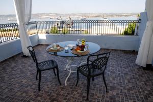 a table and chairs on a balcony with a view at A Casa da Nelly Augusta in Augusta +14 photos