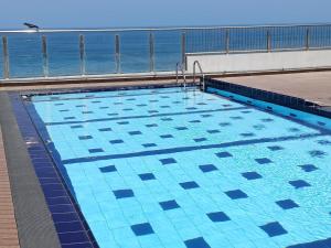 a swimming pool with the ocean in the background at A-ONE Residency in Colombo