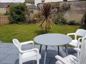 a white table and chairs sitting on a patio at Little Dover Cottage in Ryde