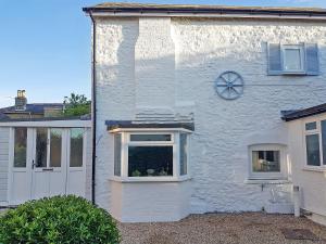 a white house with a window and a door at Little Dover Cottage in Ryde +11 photos