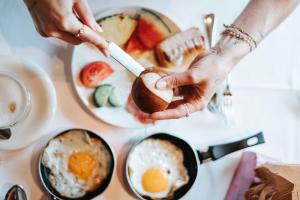 a person holding a piece of bread with eggs on a table at Hotel Glemmtalerhof in Saalbach-Hinterglemm