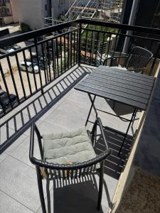 a table and chair sitting on a balcony at Bella-1 Apartment in Prishtinë +8 photos
