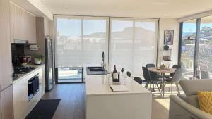 a kitchen and living room with a table and chairs at beach pad in Wollongong