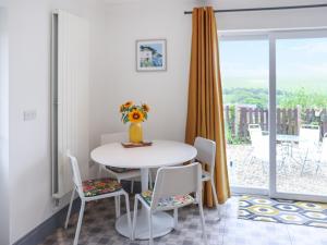 a white dining room with a table and chairs at Penally Heights Annex in Penally