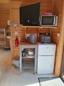 a small kitchen with a tv and a microwave at The Hut B & B in Mochdre