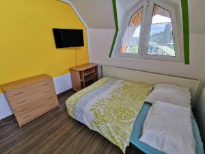 a small bedroom with a bed and a tv at Napospart 33 in Balatonlelle
