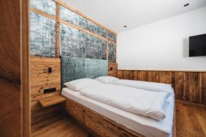 KlippitztorlにあるMoselebauerAlmのベッドと壁掛けテレビのある寝室