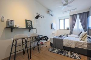 ein Schlafzimmer mit einem Bett und zwei Barhockern in der Unterkunft Riveria City By Nexx Field in Kuala Lumpur