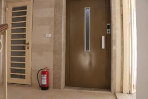 a fire hydrant next to a door with a fire extinguisher at Amaretraouf عماره رؤوف 