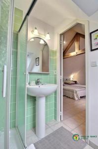 a bathroom with a sink and a mirror and a bed at Le verger in Pluneret