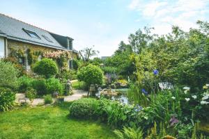 a garden in front of a house with flowers at Le verger in Pluneret
