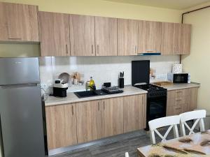 a kitchen with wooden cabinets and a refrigerator at Apartamentele Liliacul in Sighetu Marmaţiei