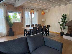 a living room with a couch and a table and chairs at Villa JANE vue Bassin in Lège-Cap-Ferret