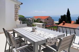 a table on a balcony with a view of the ocean at Apartments Diana - NEW heated pool in Bol