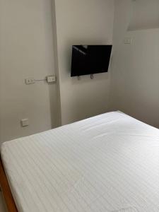 - une chambre avec un lit et une télévision murale dans l'établissement Condo Studio at Baguio Fog Fern Transient Home, à Baguio