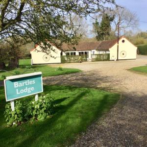 a sign in front of a house with a yard at Bartles Lodge in Elsing