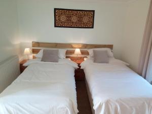 two beds sitting next to each other in a room at Bartles Lodge in Elsing