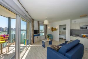 a living room with a blue couch and a balcony at Résidence Goélia Le Phare in Le Tréport