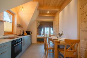 a kitchen with a table and chairs in a room at Apartamenty Tatra Loft in Ząb +75 photos