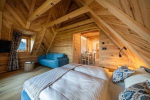 a bedroom in a log cabin with a bed and a chair at Apartamenty Tatra Loft in Ząb