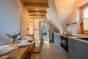 a kitchen with a wooden table and a counter top at Apartamenty Tatra Loft in Ząb