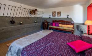 a bedroom with a large bed and a couch at Appartamenti Podere San Sebastiano in Castiglione della Pescaia
