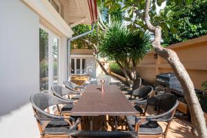 a long wooden table and chairs on a patio at Naka Villa at Pratumnak in Pattaya South