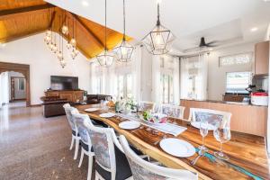a dining room with a long wooden table and chairs at Naka Villa at Pratumnak in Pattaya South