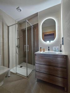a bathroom with a shower and a sink and a mirror at Villanueva 5 in Luces +34 photos