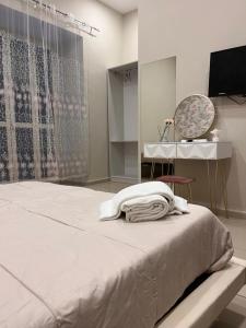 Un dormitorio con una cama, una mesa y un televisor. en International Hotels, en Nápoles