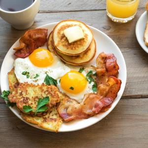 - un plateau de petit-déjeuner composé d'œufs, de bacon et de crêpes dans l'établissement Lumbs', à Jaipur
