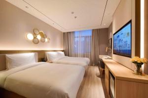 ein Hotelzimmer mit zwei Betten und einem Flachbildfernseher in der Unterkunft Orange Beijing Yanqing Badaling Great Wall Hotel in Xibozi