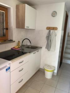 a kitchen with white cabinets and a sink at Hiša Seča Sunset in Portorož