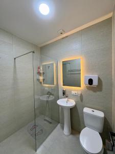 a bathroom with a toilet and a sink and a shower at Sataplia Inn in Tskaltubo