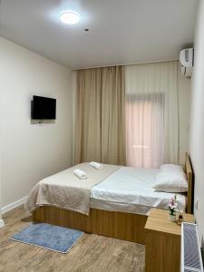 a bedroom with a large bed and a television at Sataplia Inn in Tsqaltubo