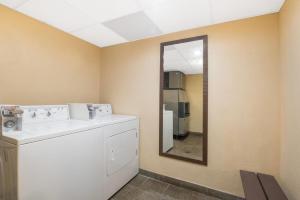 a bathroom with a washing machine and a mirror at Days Inn by Wyndham Duluth Lakewalk in Duluth +32 photos
