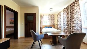 a bedroom with a bed and a table and chairs at LUBNOWO Agro Tour in Lubnowo