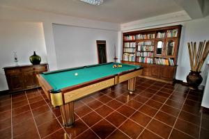 a room with a pool table and a book shelf at Casa do Adro de Parada in Parada de Pinhão