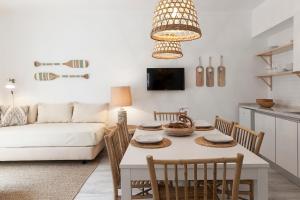 a living room with a table and a white couch at Mare Cheia (High Tide) Beach and Surf Apartments in Peniche