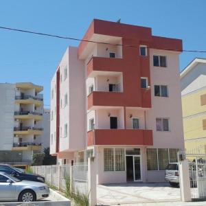 a tall building with cars parked in front of it at Hotel Ardian in Golem