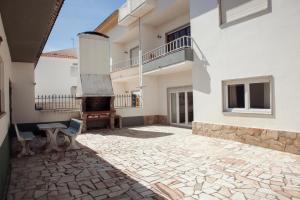 a courtyard of a house with a stone floor at Mare Cheia (High Tide) Beach and Surf Apartments in Peniche