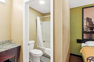 a small bathroom with a toilet and a shower at Super 8 by Wyndham Cincinnati-Springdale OH in Springdale +43 photos