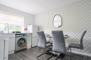 a kitchen with a table and chairs and a washing machine at Harburn House in West Calder