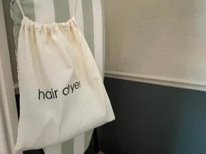 a white bag with the word hair cure written on it at Wedgwood Hotel, North Shore Room in Llandudno +1 photo