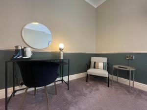 a room with a desk and a mirror and a chair at Wedgwood Hotel, North Shore Room in Llandudno