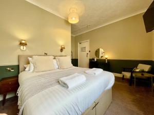 a bedroom with a large bed with two towels on it at Wedgwood Hotel, North Shore Room in Llandudno